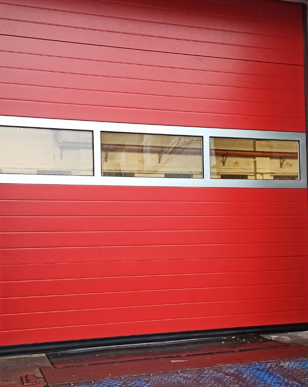 Leistungsstarkes Industrie-Sektionaltor in rot mit Fenster