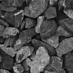 Eine Nahaufnahme mehrerer unregelmäßig geformter grauer Basaltsteine, die aufeinander gestapelt sind.