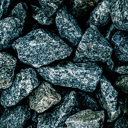 Eine Nahaufnahme mehrerer unregelmäßig geformter grauer Granitsteine, die aufeinander gestapelt sind.