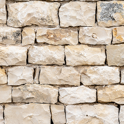 Eine Nahaufnahme mehrerer unregelmäßig geformter grauer Kalksteine, die aufeinander gestapelt sind.