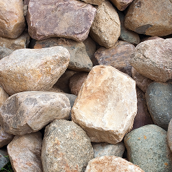 Eine Nahaufnahme mehrerer unregelmäßig geformter grauer Quarzitsteine, die aufeinander gestapelt sind.